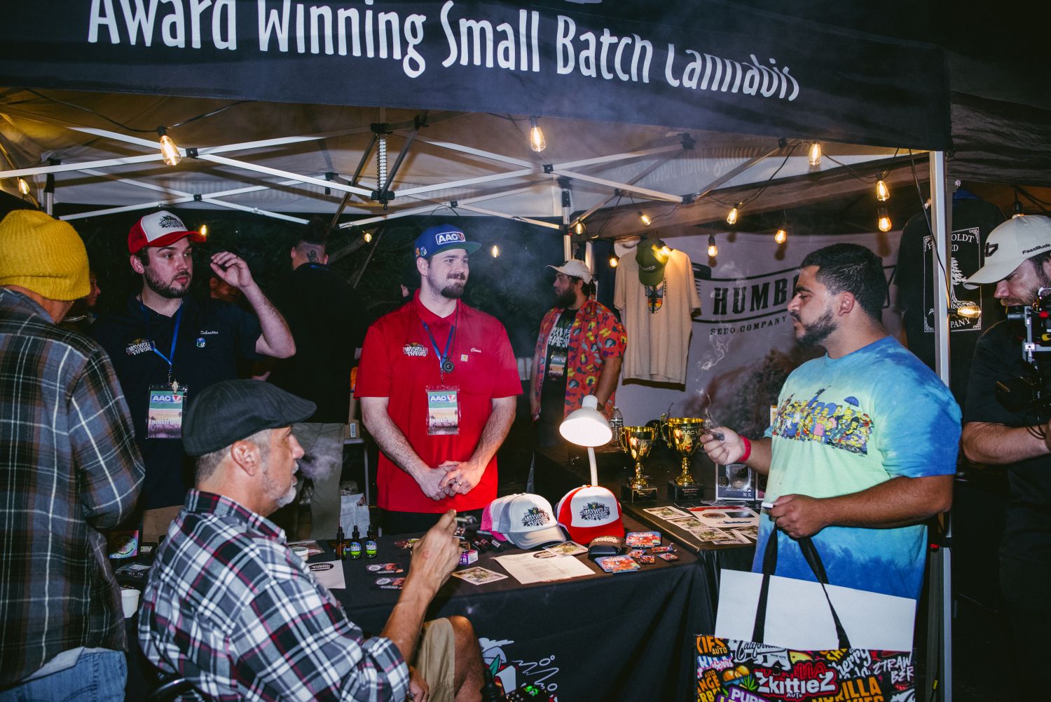 endors and attendees at an award-winning small batch cannabis booth with trophies at the AAC event in Los Angeles
